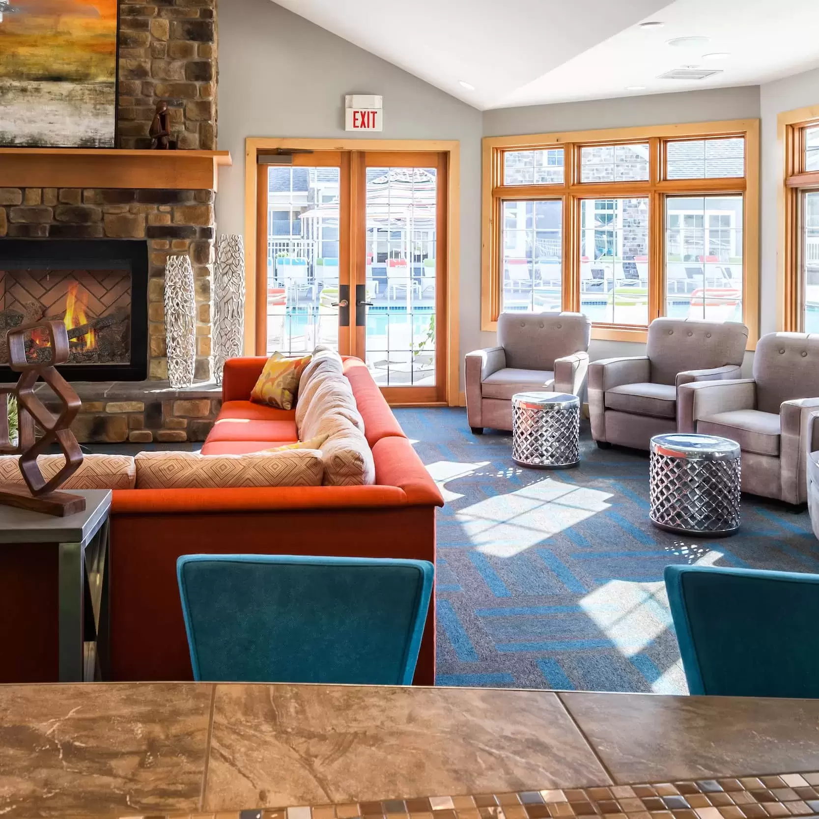 In the Resident Hub a big comfy couch and chairs sit in front of a large stone fireplace.