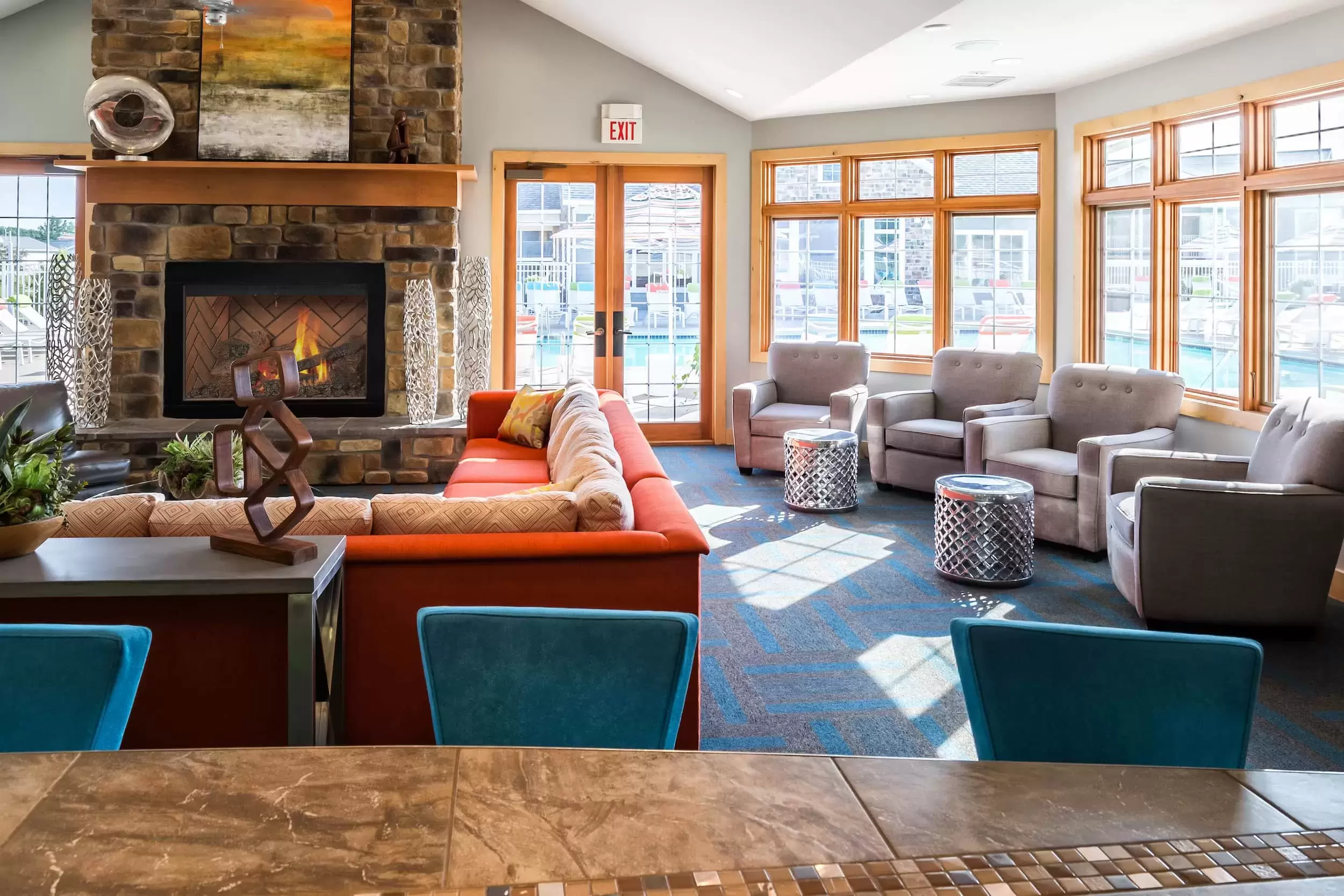 In the Resident Hub a big comfy couch and chairs sit in front of a large stone fireplace.